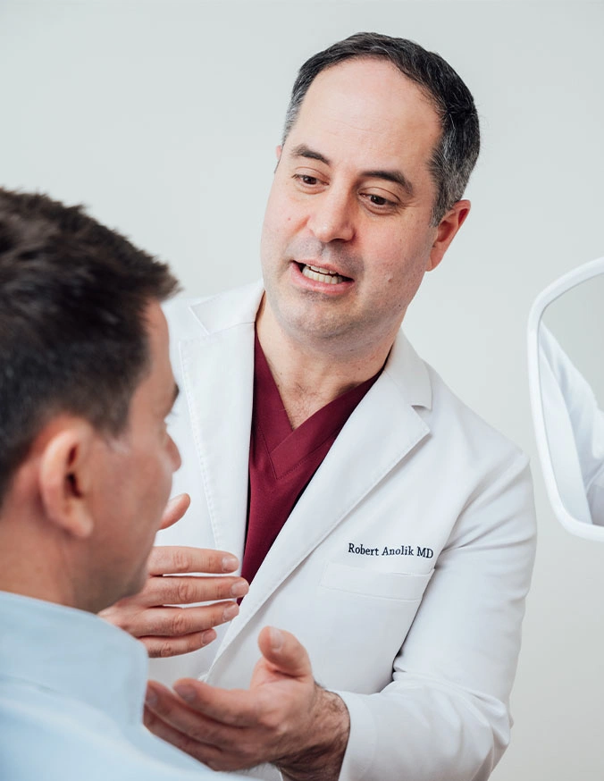 Doctor in white coat consulting with male patient in medical office setting