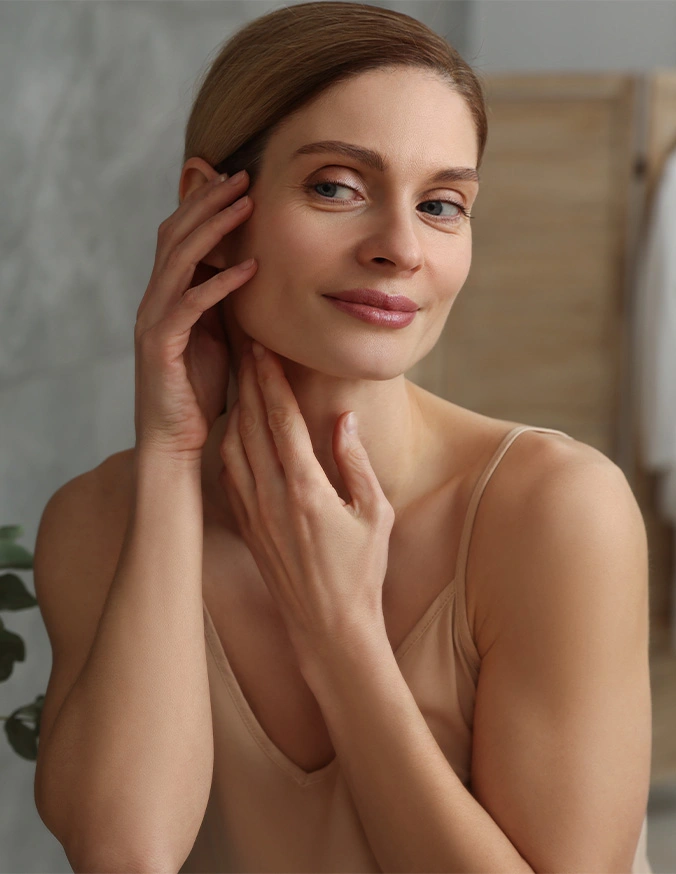 Woman with smooth skin touching her face and neck in skincare beauty routine pose