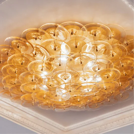 Amber glass bubble ceiling light fixture with warm glow in elegant room with crown molding